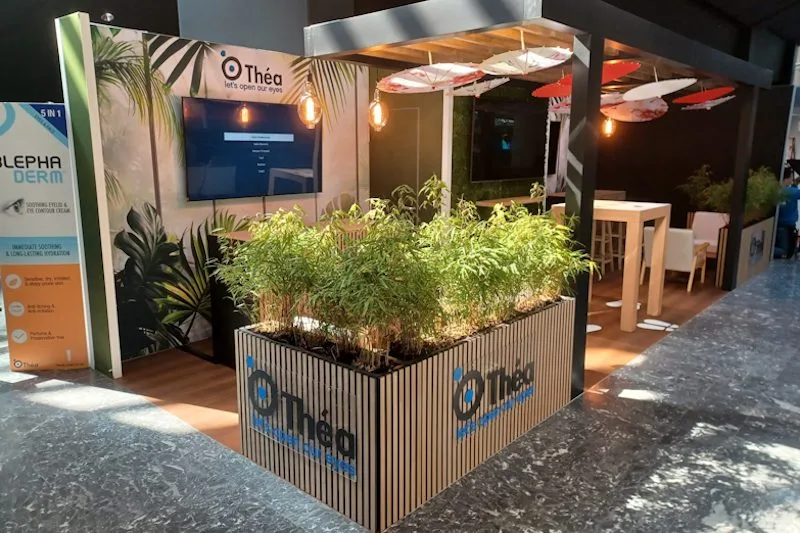 In deze modulaire beursstand van Théa Pharma hebben we veel van onze modulaire componenten verwerkt. De stand heeft systeemkaders, waarbij we de voorzijde van de berging hebben afgewerkt met onze mos-invulpanelen. Er zijn modulaire balies en plantenbakken met houten latjes. De modulaire koof doet dienst als plafond en op de vloer ligt loose lay-vloerafwerking.